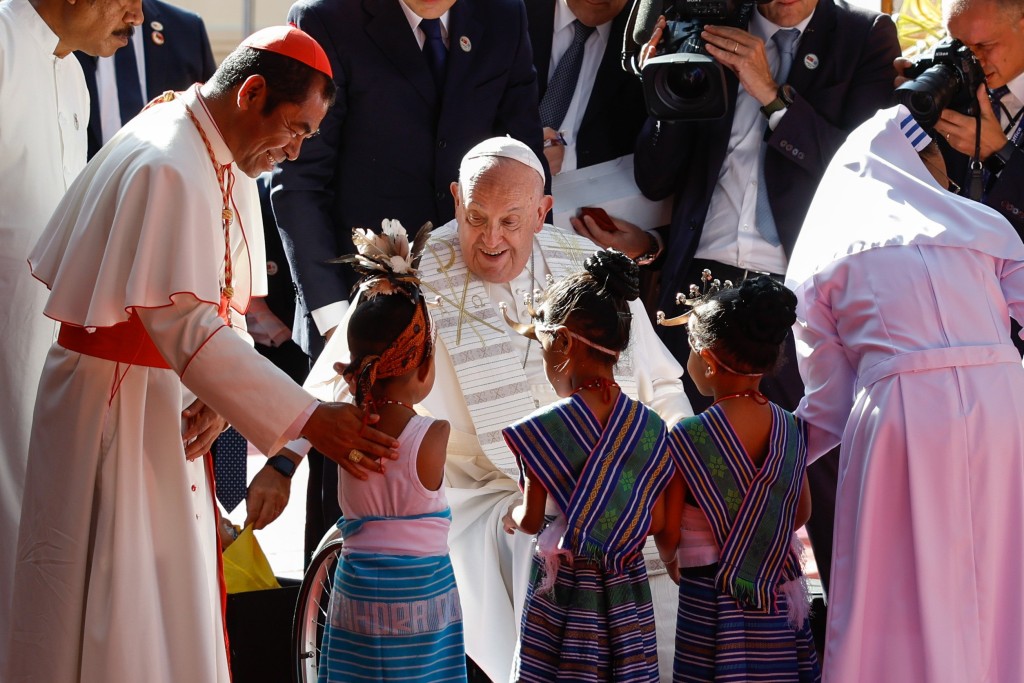 Pope Francis greets children in traditional dress during a visit with children who are seriously ill or have severe disabilities at the Irmas Alma School in Dili, Timor-Leste.