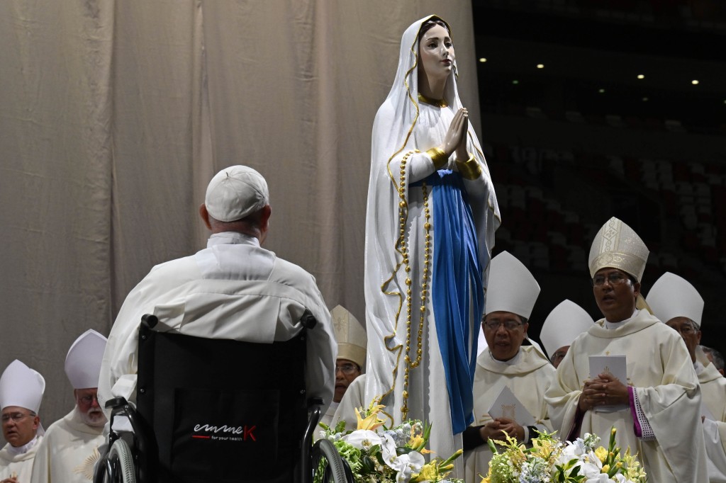 Pope Francis venerates a statue of Our Lady after Mass at Singapore's National Stadium Sept. 12, 2024, the feast of the Holy Name of Mary. 