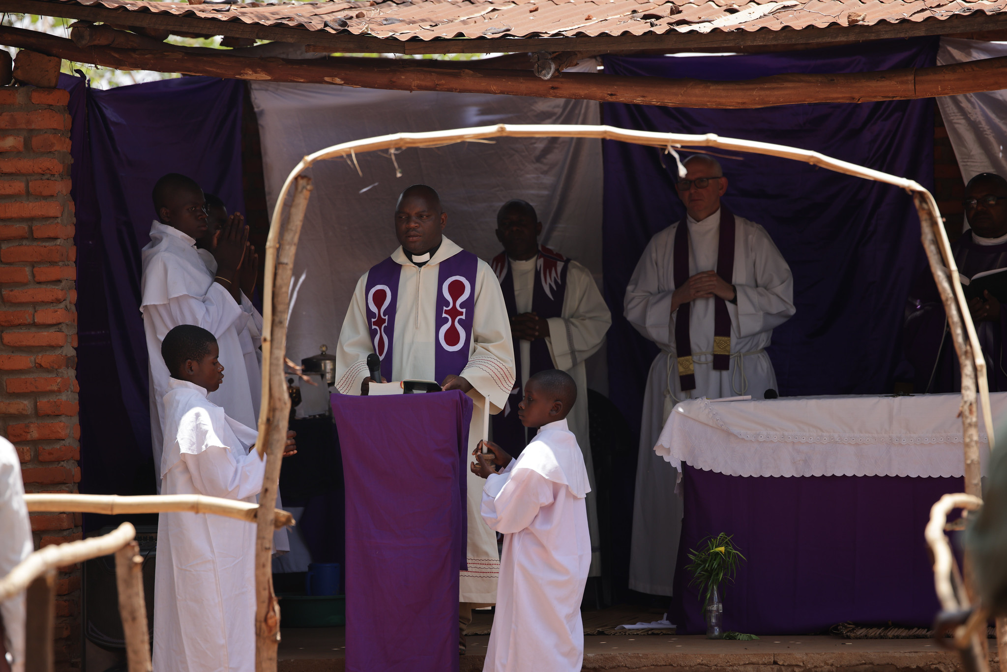  A modest brick structure next to the old church serves as the current place of worship: a small shed with three walls is the sanctuary where the sacrifice of the Mass happens