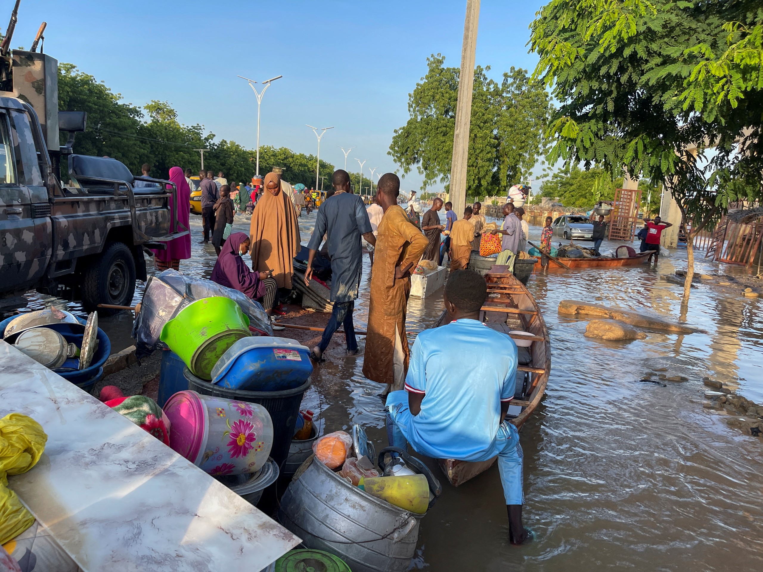 Flood victims are pictured alongside their belongings along a flooded road as they move to safety, in Maiduguri, Nigeria, Sept. 17, 2024.