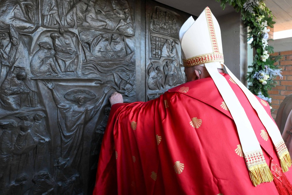 On the feast of St. Stephen, Pope Francis knocks on the Holy Door of the Church of Our Father at Rome's Rebibbia prison Dec. 26, 2024, before opening it and presiding over a Mass with inmates, prison staff and Italian government officials Dec. 26, 2024. (CNS photo/Vatican Media)