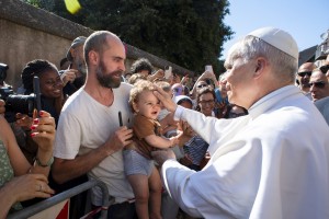 Pope Leo XIV greets a child as he arrives in Castel Gandolfo.